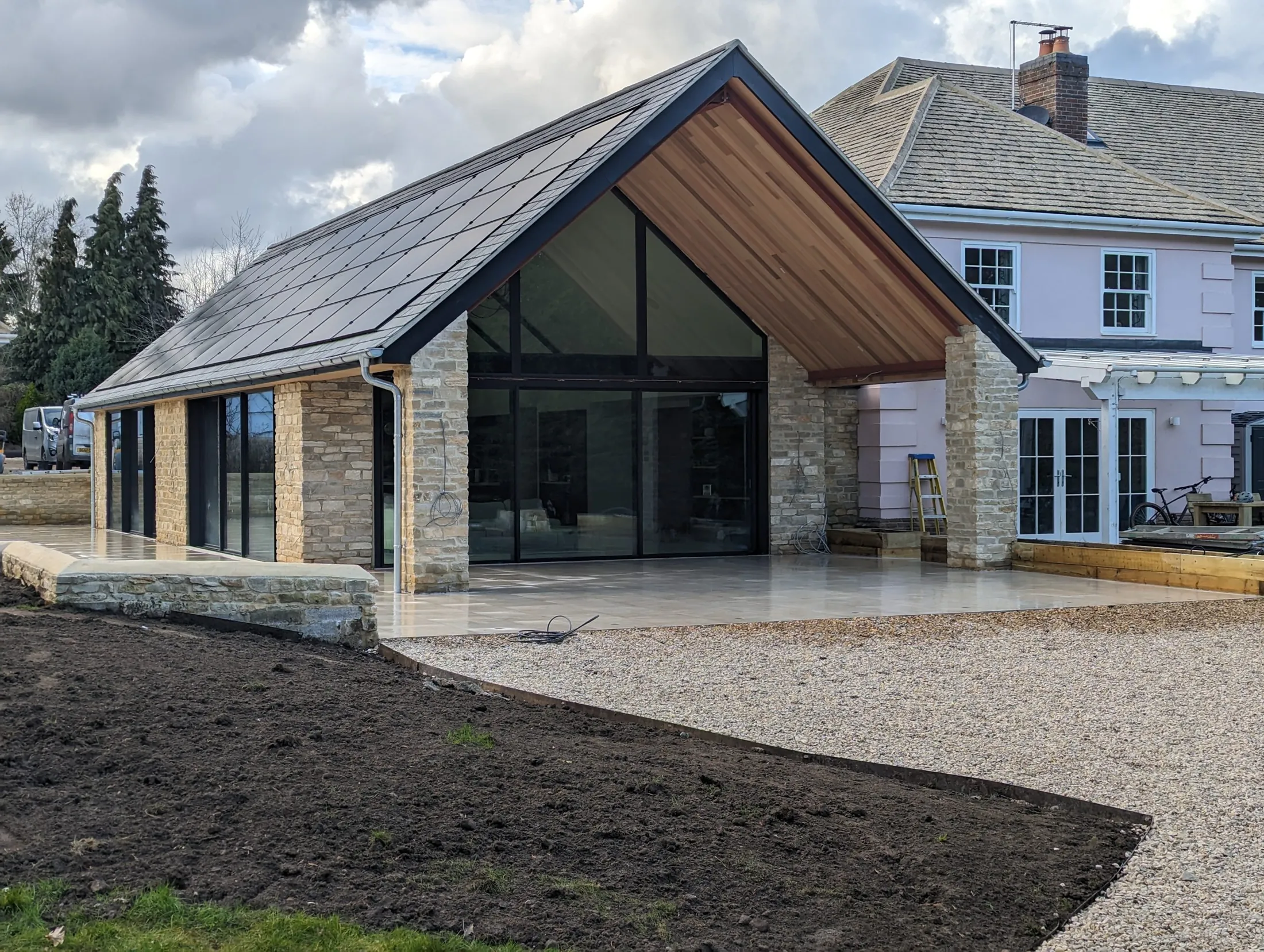 Stone new build with a fully glazed gable end and timber soffit