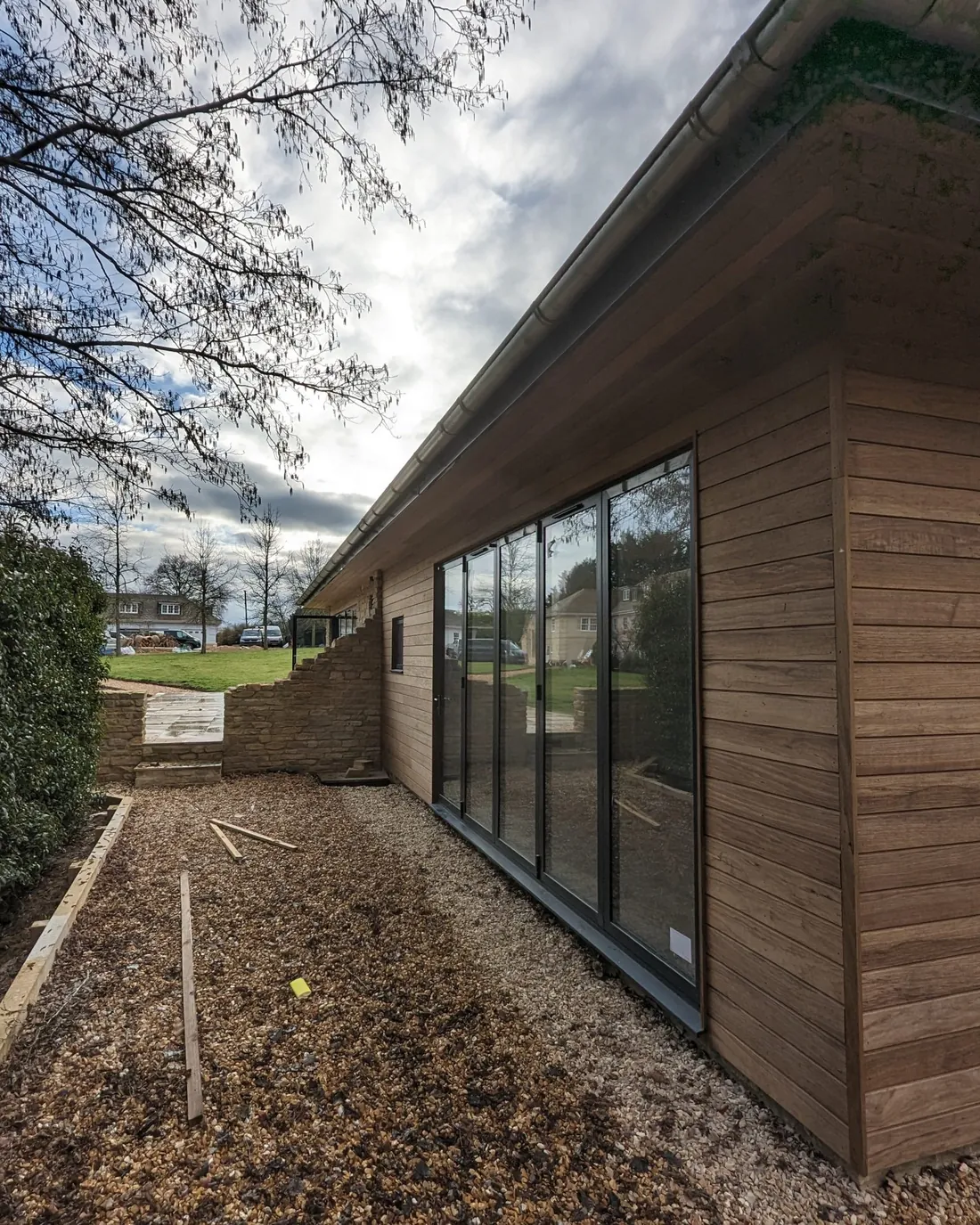 Cedar-clad garden building with floor-to-ceiling glazing